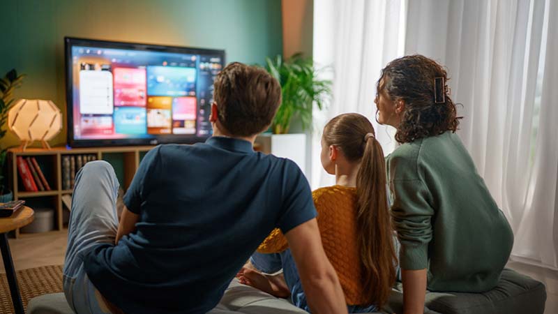 Família a ver televisão na sala